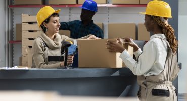 Diverse warehouse team using bar code scanners to manage packages