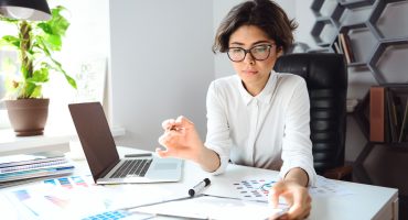 Young beautiful businesswoman sitting at workplace in office.